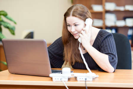 Executive attractive business woman making telephone calls in officeの写真素材
