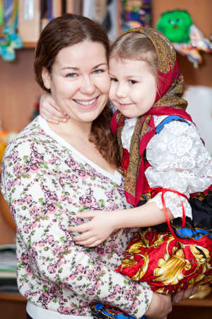 Happy mother holding small girl in Russian traditional clothesの写真素材