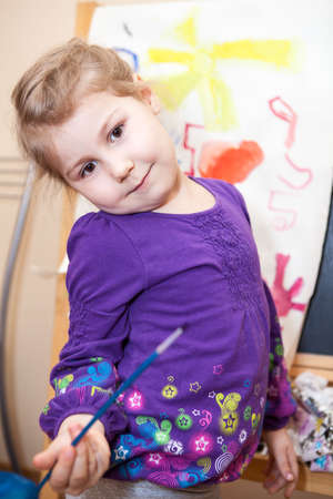 Small expression child painting a picture with brush and paintsの写真素材