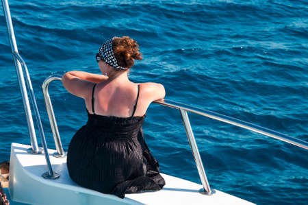 Young woman on bow of yacht in Mediterranean sea cruiseの写真素材