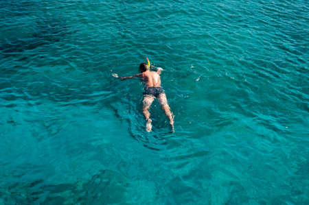 One young man snorkeling in azure seaの写真素材