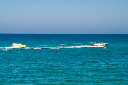 PROTARAS, CYPRUS - CIRCA SEPTEMBER, 2010: Enjoying skiing on inflatable behind speed boat , on circa...