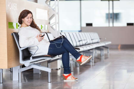 Cheerful joyful Caucasian woman spending time in airport loungeの写真素材