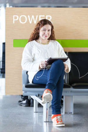 Woman working with electronic devices in place to chargeの写真素材