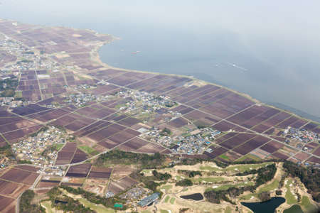 Rice meadows and fields with small Japanese villages and towns on Pacific Ocean. Aerial view from aircraft. Japanの写真素材