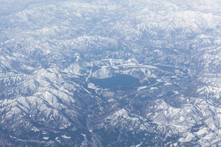 Mountain lake in the middle of snowcovered range, Japan. Aerial viewの写真素材