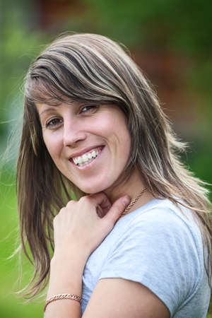 Smiling Caucasian woman portrait with long hair, outdoorsの写真素材
