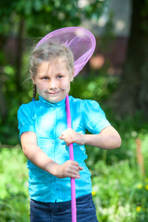 Happy child standing in sunlights with butterfly net at summer dayの写真素材
