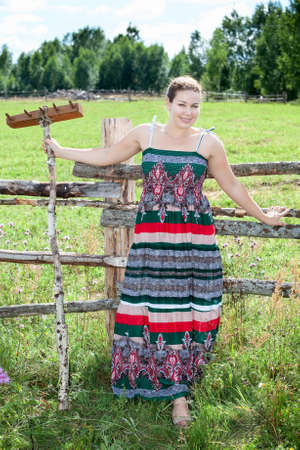 Pretty brunette with rake in a fieldの写真素材