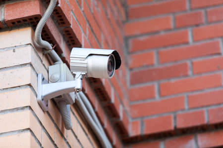 Video surveillance camera in courtyard on brick wallの写真素材