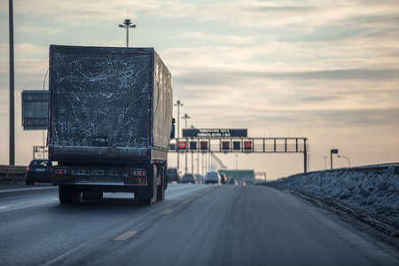 Truck on dirty winter ring road in the evening.の写真素材
