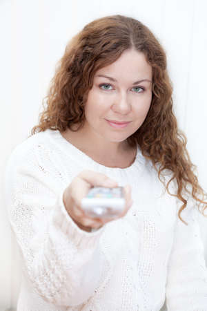 Calm Caucasian woman with tv remote control isolated on white background