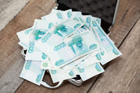 Steel case with Russian banknotes inside on wooden floorの写真素材