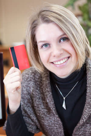 Smiling Caucasian woman showing credit card in handの写真素材