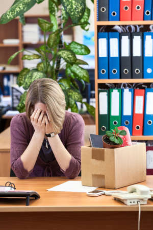 Dismissed woman crying, sitting at your deskの写真素材