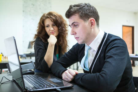 Displeased young people reading some bad news with laptopの写真素材