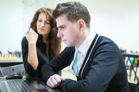 Young couple looking at pc screen with serious lookの写真素材