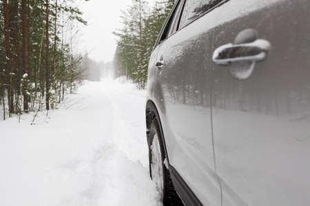 Offroad vehicle on snowy forest road, side viewの写真素材