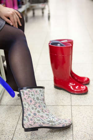 Dressing and buying rainboots in shoeshopの写真素材