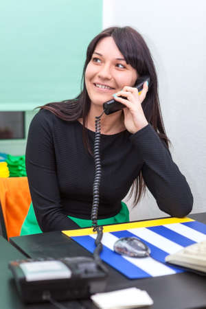 Happy businesswoman talking on  telephone in officeの写真素材