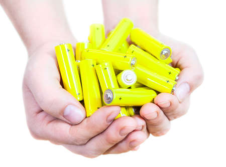 Caucasian handful with lot yellow penlight batteries isolated on white backgroundの写真素材