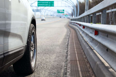 Car standing on wayside of highway with road view at distanceの写真素材