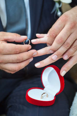 Groom wearing wedding ring on bride fingerの写真素材
