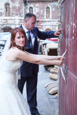 Newly wedding Caucasian couple trying to open doorsの写真素材
