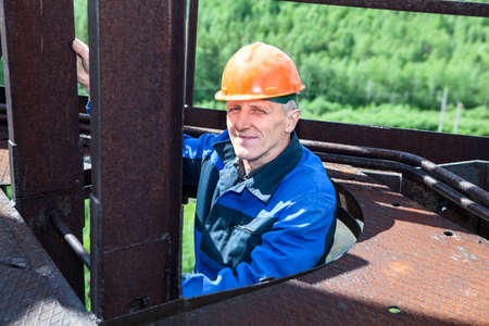 Senior worker climbing up for maintenance worksの写真素材