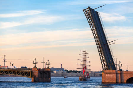 SAINT-PETERSBURG, RUSSIA - CIRCA JUNE, 2013  Sailfish with Red sails passing under opened span of the Trinity bridge on Neva river during the White Nights Festival  Vessel is a symbol of the end of school yearの写真素材