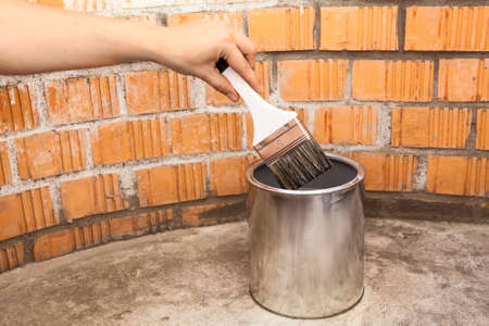 Clear paint brush deeping in full can