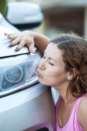 Young woman kissing her new carの写真素材