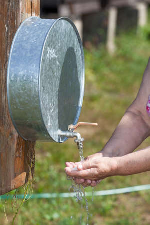 Senior person washing hands in standwasherの写真素材