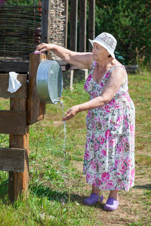 Senior woman washing her hands with soap in washstandの写真素材