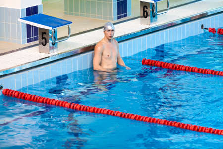 Swimmer standing in water of swimming poolの写真素材