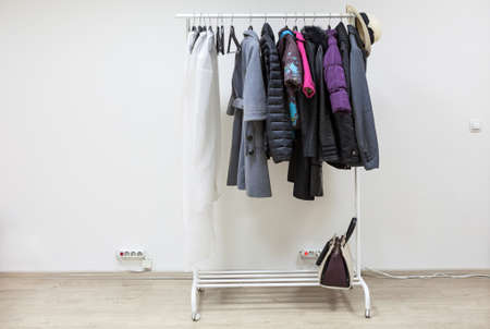Simple interior of hallway with clothes on hangers, copy space