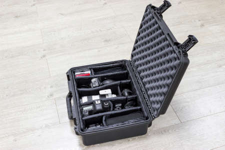 Protector plastic case with photo equipments inside is on the floorの写真素材