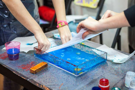 Process of printing inks from water surface into silk, ebru marblingの写真素材