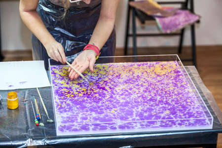 Painter hands splashing inks on water surface for marblingの写真素材