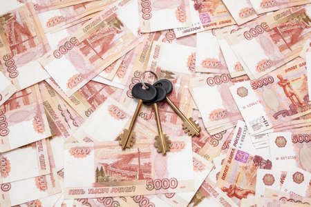 House key laying on Russian cash money