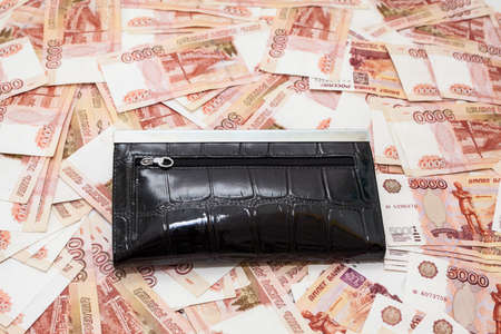 Black purse on scattered five thousandth banknotes of rubles