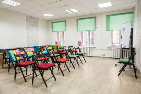 Chairs with colored capes in the hall for seminar or meetingの写真素材