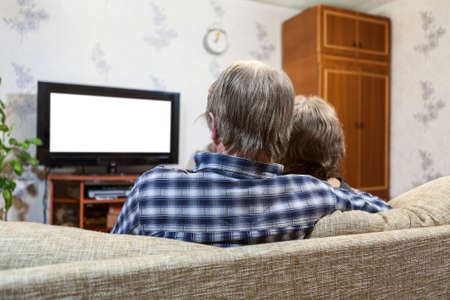 Caucasian family from two people sitting on the couch and watching tv, rear view, isolated white screenの写真素材