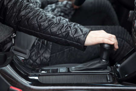 Side close-up view of human hand changing levels of automatic car gearboxの写真素材