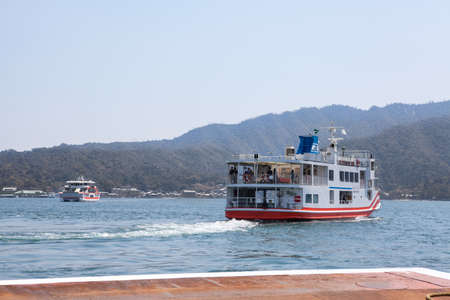 MIYAJIMAGUCHI, JAPAN - CIRCA APR, 2013: Ferry-boat of JR company starts cruise to the island of Miyajima (Itsukushima) in Hiroshima gulf. View from the Miyajimaguchi city pierのeditorial素材