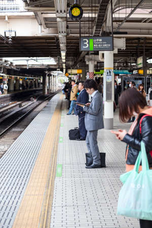 TOKYO, JAPAN - CIRCA APR, 2013: People wait for train arrival on the Japanese rail station at Yamamoto line. The Yamamoto is a railway loop line in Tokyo, Japan,のeditorial素材