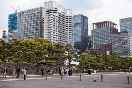 TOKYO, JAPAN - CIRCA APR, 2013: Asian tourists stand near the Tokyo Imperial Palace entrance and wait for tour beginning. The Tokyo Imperial Palace is the main residence of the Emperor of Japanのeditorial素材