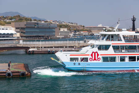 MIYAJIMAGUCHI, JAPAN - CIRCA APR, 2013: The ferry of Matsudai Kisen company moors to Miyajimaguchi town pier. Two ferry-boats for Itsukushima island travel. The Hiroshima gulf, Japan.のeditorial素材