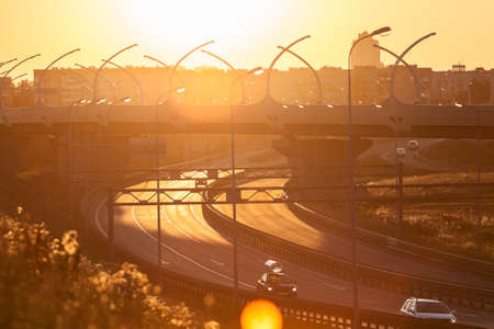 Exits of city highway in sunset light with driving vehiclesの写真素材