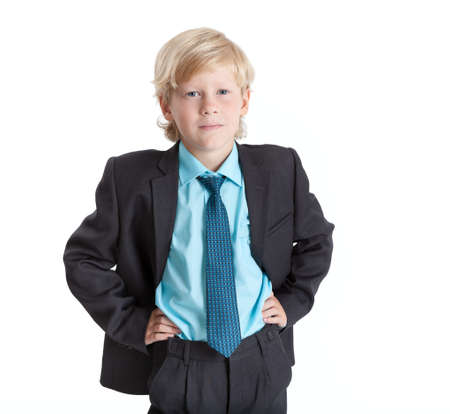 Schoolboy blond hair boy in school uniform, hands on hips, isolated on white backgroundの写真素材